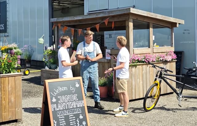 Jan de Plantenman in zijn tuinpak voor de winkel in Monster